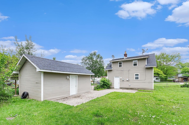 12023 Norborne, Redford, MI 48239 - rear view of property featuring a lawn, an outbuilding, a chimney, and a shingled roof