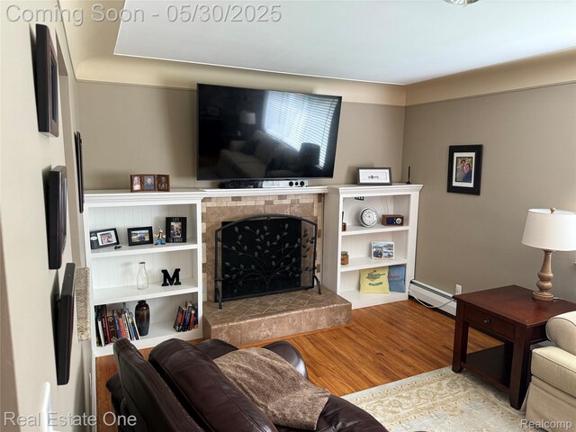 53216 Bruce Hill Dr, Shelby Twp, MI 48316 - living area with a baseboard radiator, a tiled fireplace, and wood finished floors