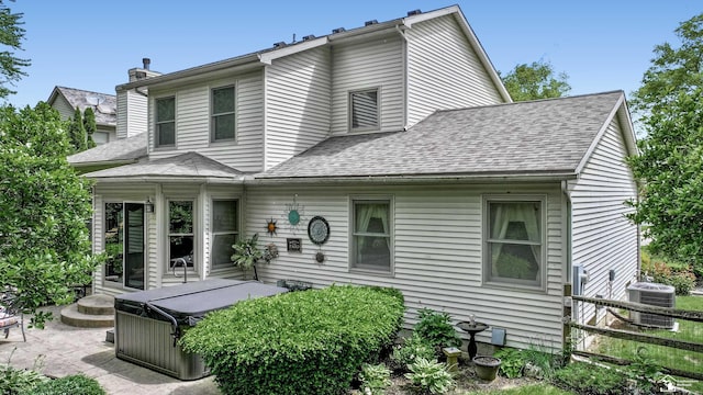 6757 Lockmill Rd, Temperance, MI 48182 - view of front of property featuring central air condition unit, a hot tub, a patio area, a shingled roof, and a chimney