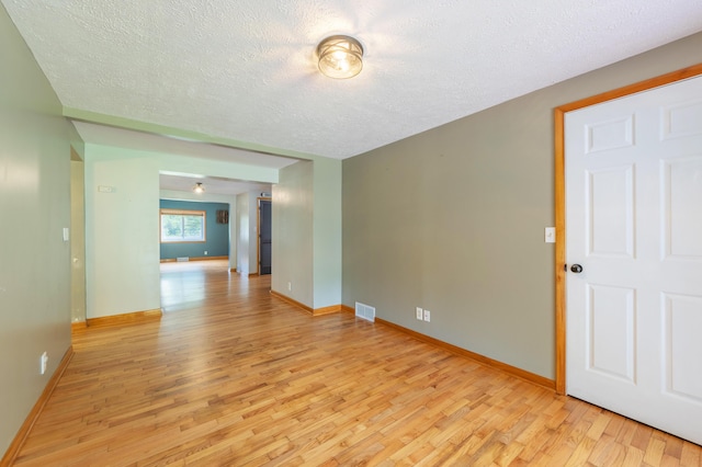 6210 Johnson Rd, Coloma, MI 49038 - unfurnished room with light wood-style floors, a textured ceiling, and baseboards