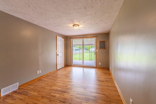 6210 Johnson Rd, Coloma, MI 49038 - empty room featuring light wood-style flooring, a textured ceiling, and baseboards