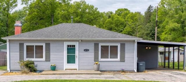 6210 Johnson Rd, Coloma, MI 49038 - view of front of house with a chimney, a carport, and roof with shingles
