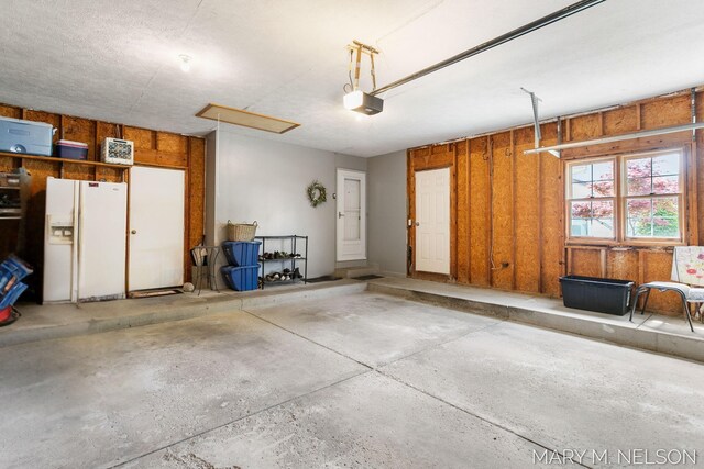 5540 Koster Dr SW, Wyoming, MI 49418 - garage featuring white fridge with ice dispenser and a garage door opener