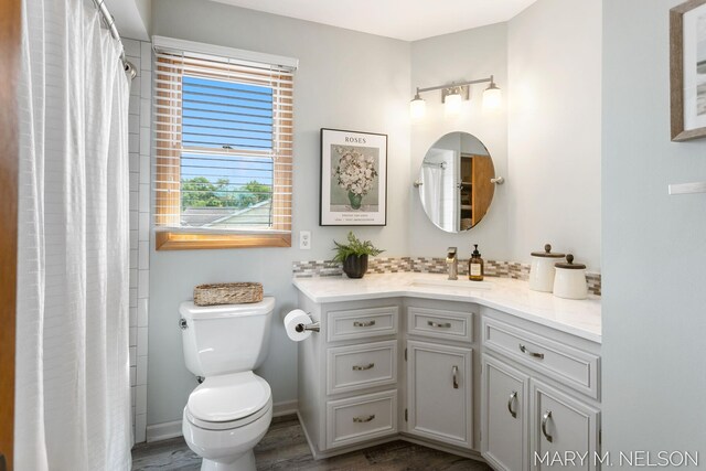 5540 Koster Dr SW, Wyoming, MI 49418 - bathroom with vanity, toilet, wood finished floors, and baseboards