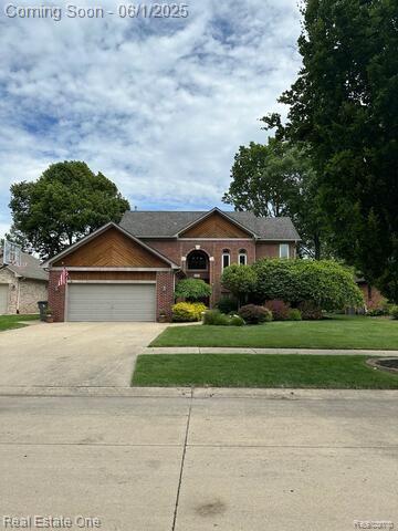 39888 Brylor, Clinton Township, MI 48038 - view of front of home with concrete driveway, an attached garage, a front lawn, and brick siding