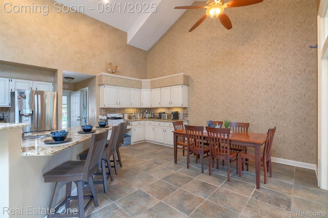 39888 Brylor, Clinton Township, MI 48038 - dining space with high vaulted ceiling, a ceiling fan, dark stone finish floors, wallpapered walls, and baseboards