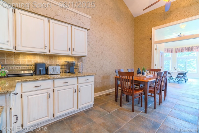39888 Brylor, Clinton Township, MI 48038 - dining space featuring wallpapered walls, ceiling fan, vaulted ceiling, baseboards, and dark stone finish flooring