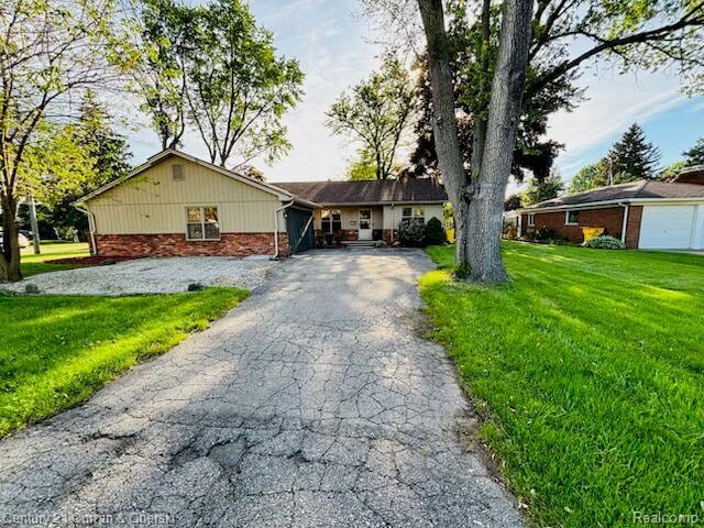 45215 Custer Ave, Utica, MI 48317 - ranch-style house featuring a front lawn, driveway, and brick siding