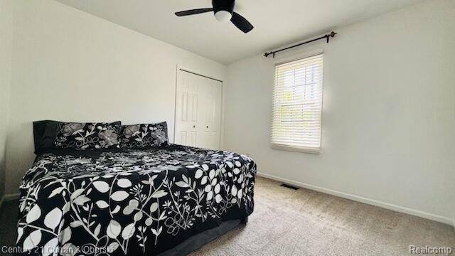 45215 Custer Ave, Utica, MI 48317 - bedroom featuring baseboards, carpet, a closet, and a ceiling fan