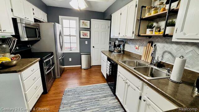 45215 Custer Ave, Utica, MI 48317 - kitchen with appliances with stainless steel finishes, dark wood finished floors, white cabinetry, and decorative backsplash