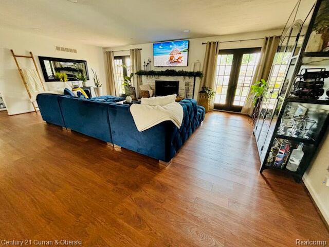 45215 Custer Ave, Utica, MI 48317 - living area featuring wood finished floors, plenty of natural light, and a fireplace