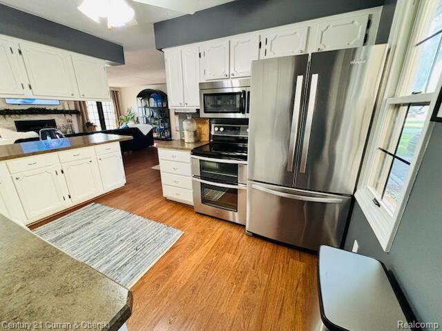 45215 Custer Ave, Utica, MI 48317 - kitchen featuring stainless steel appliances, light wood-type flooring, and white cabinetry