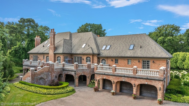 975 Sunningdale Dr, Bloomfield Hills, MI 48302 - back of house featuring a chimney, curved driveway, an attached garage, and brick siding