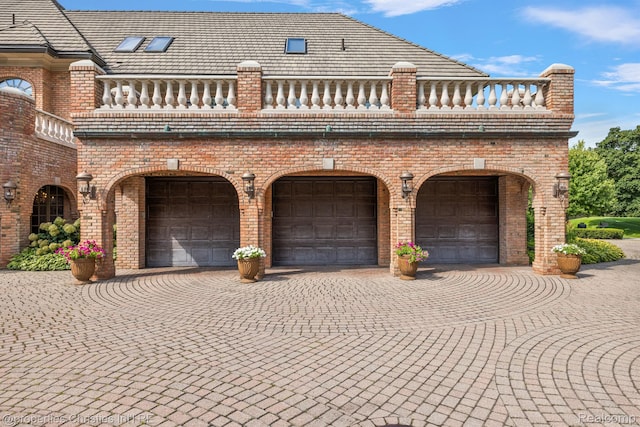 975 Sunningdale Dr, Bloomfield Hills, MI 48302 - view of front of house with brick siding, an attached garage, a balcony, and decorative driveway