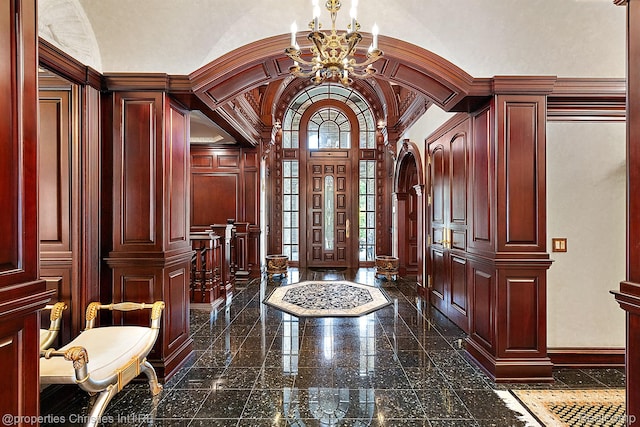 975 Sunningdale Dr, Bloomfield Hills, MI 48302 - entrance foyer with granite floors, a chandelier, a decorative wall, arched walkways, and baseboards
