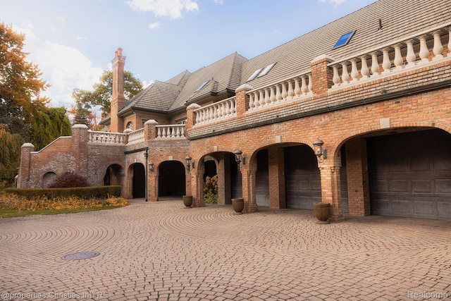 975 Sunningdale Dr, Bloomfield Hills, MI 48302 - view of front facade with a balcony, brick siding, a high end roof, and curved driveway
