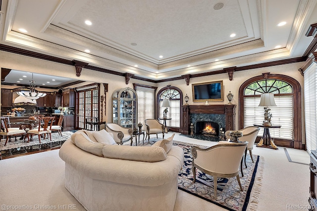 975 Sunningdale Dr, Bloomfield Hills, MI 48302 - carpeted living area featuring a premium fireplace, a raised ceiling, plenty of natural light, ornamental molding, and a chandelier