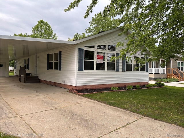 504 Bush Lake Ln, Smiths Creek, MI 48074 - view of front of house with concrete driveway, an attached carport, and a front yard