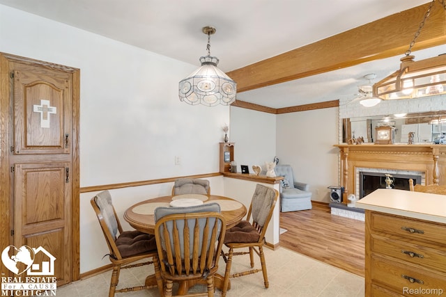 15179 Norman St, Livonia, MI 48154 - dining area with beamed ceiling, a fireplace with raised hearth, and baseboards