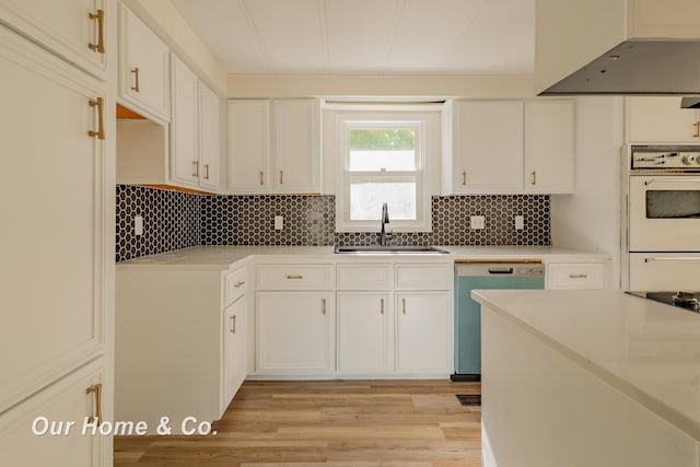 838 S Grey Rd, Midland, MI 48640 - kitchen with a sink, dishwasher, wall chimney range hood, light wood-style flooring, and light countertops