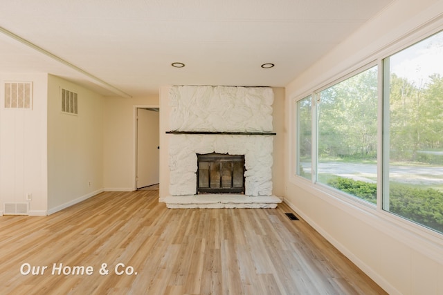 838 S Grey Rd, Midland, MI 48640 - unfurnished living room featuring baseboards, light wood-style flooring, and a stone fireplace