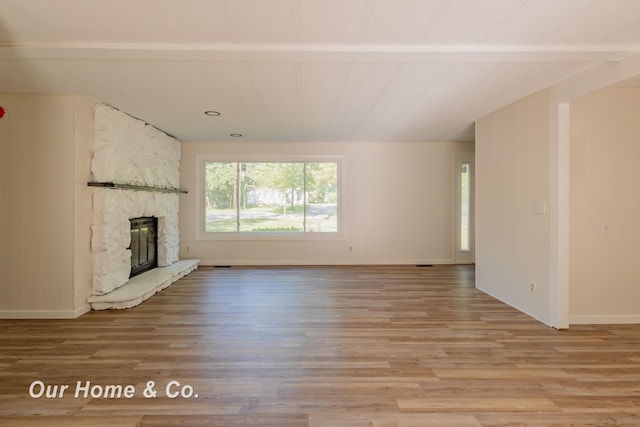 838 S Grey Rd, Midland, MI 48640 - unfurnished living room featuring light wood-style flooring, a stone fireplace, baseboards, and recessed lighting