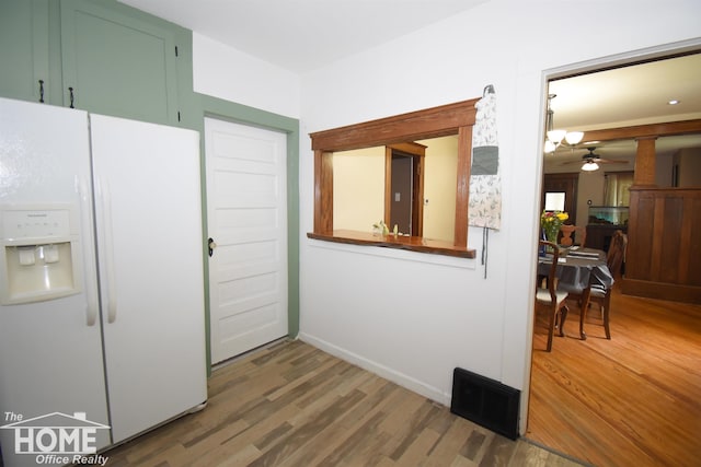 231 W Ridge St, Owosso, MI 48867 - kitchen with white refrigerator with ice dispenser, wood finished floors, ceiling fan, and baseboards