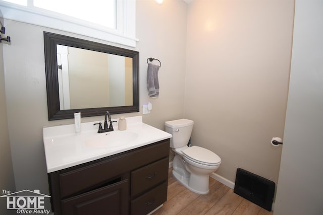 231 W Ridge St, Owosso, MI 48867 - half bath featuring vanity, toilet, and wood finished floors
