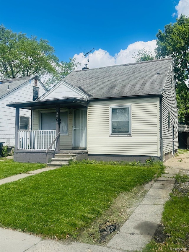 8068 Stahelin Ave, Detroit, MI 48228 - view of front of home with a front lawn, covered porch, and roof with shingles