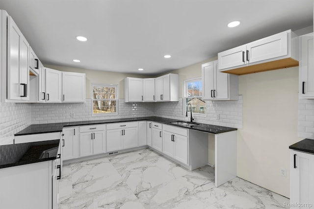 551 Englewood St, Detroit, MI 48202 - kitchen with a sink, light marble finish floors, recessed lighting, tasteful backsplash, and white cabinetry