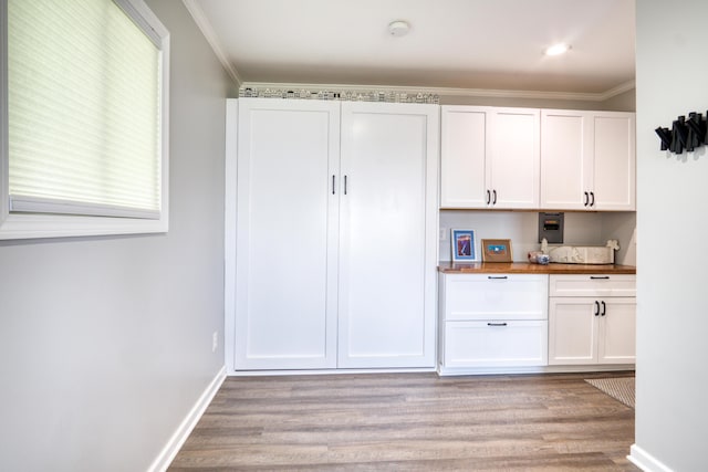 6132 W Houghton Lake Dr, Houghton Lake, MI 48629 - kitchen featuring light wood-type flooring, white cabinetry, ornamental molding, baseboards, and butcher block counters