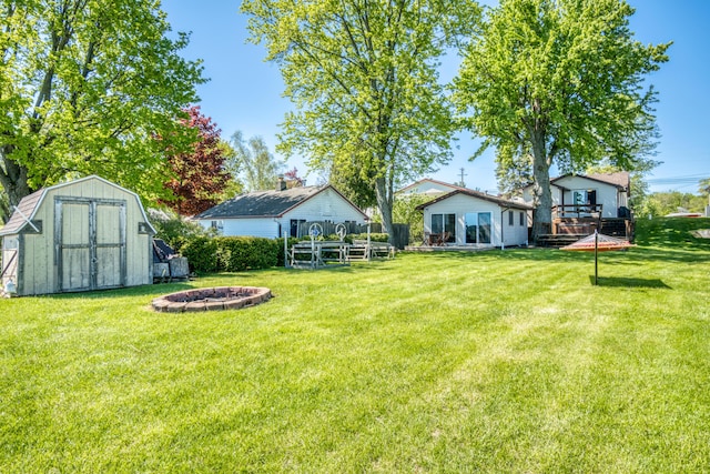 6132 W Houghton Lake Dr, Houghton Lake, MI 48629 - view of green lawn with an outdoor fire pit and a deck