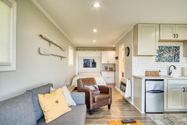 6132 W Houghton Lake Dr, Houghton Lake, MI 48629 - kitchen with freestanding refrigerator, heating unit, a sink, crown molding, and tasteful backsplash