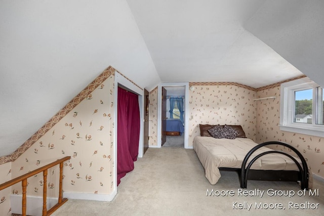 607 E Coffren St, Greenville, MI 48838 - bedroom featuring wallpapered walls, lofted ceiling, baseboards, and carpet