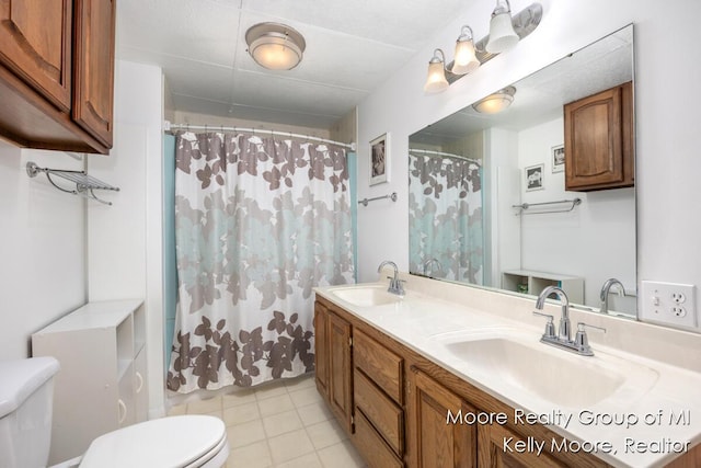 607 E Coffren St, Greenville, MI 48838 - bathroom featuring toilet, double vanity, curtained shower, and tile patterned floors