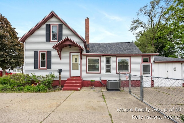 607 E Coffren St, Greenville, MI 48838 - view of front of home featuring a gate, a chimney, cooling unit, entry steps, and a shingled roof