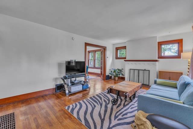 710 S 1st St, Ann Arbor, MI 48103 - living area featuring baseboards, healthy amount of natural light, a brick fireplace, and wood finished floors