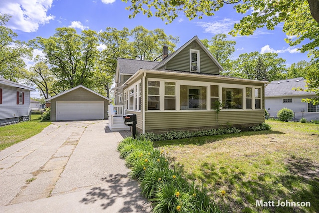 2057 Philo Ave, Muskegon, MI 49441 - view of front of property with a garage, an outdoor structure, a sunroom, a front lawn, and a chimney