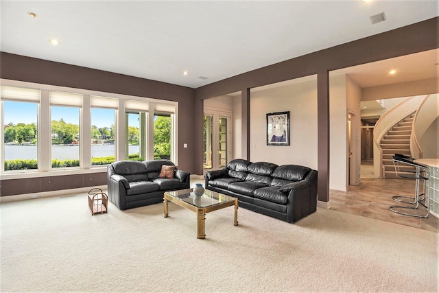 15919 Orchard Point Dr, Spring Lake, MI 49456 - living room featuring light colored carpet, recessed lighting, stairs, and a water view