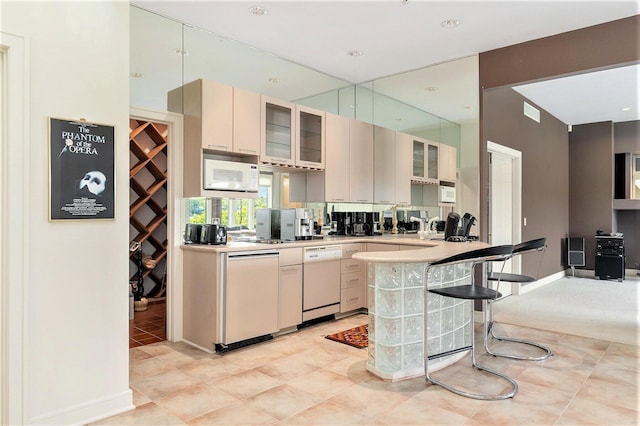 15919 Orchard Point Dr, Spring Lake, MI 49456 - kitchen featuring white appliances, a kitchen bar, a peninsula, glass insert cabinets, and light countertops