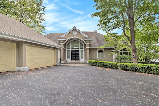 15919 Orchard Point Dr, Spring Lake, MI 49456 - view of front of house featuring stucco siding, driveway, a garage, and a shingled roof