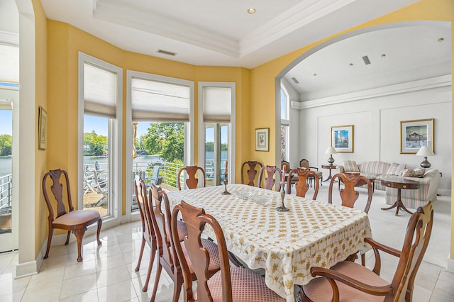 15919 Orchard Point Dr, Spring Lake, MI 49456 - dining space with arched walkways, a water view, a raised ceiling, light tile patterned flooring, and crown molding