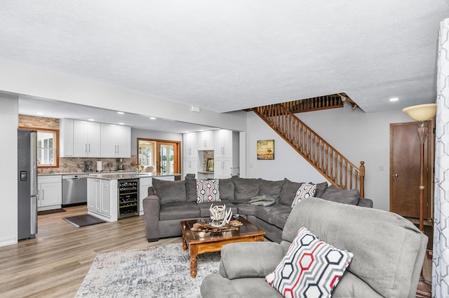 13881 Rivercrest Dr, White Pigeon, MI 49099 - living area featuring wine cooler, light wood-style floors, stairway, recessed lighting, and a textured ceiling