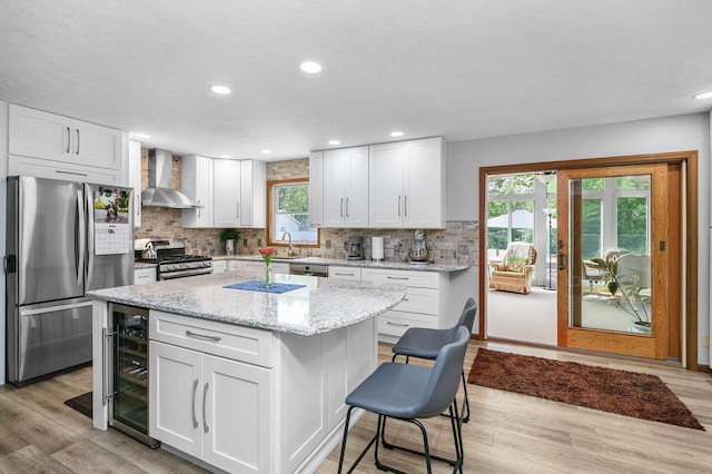 13881 Rivercrest Dr, White Pigeon, MI 49099 - kitchen featuring appliances with stainless steel finishes, wall chimney exhaust hood, wine cooler, light wood-type flooring, and recessed lighting