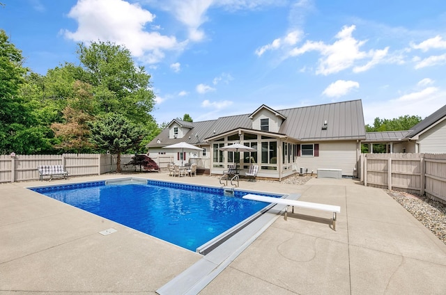 13881 Rivercrest Dr, White Pigeon, MI 49099 - view of swimming pool featuring a sunroom, a patio area, a fenced backyard, and a diving board