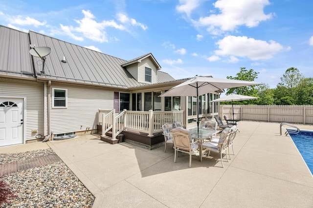 13881 Rivercrest Dr, White Pigeon, MI 49099 - rear view of house with a sunroom, a patio, a standing seam roof, metal roof, and outdoor dining area