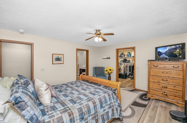 13881 Rivercrest Dr, White Pigeon, MI 49099 - bedroom featuring light wood finished floors, a spacious closet, a closet, a ceiling fan, and baseboards