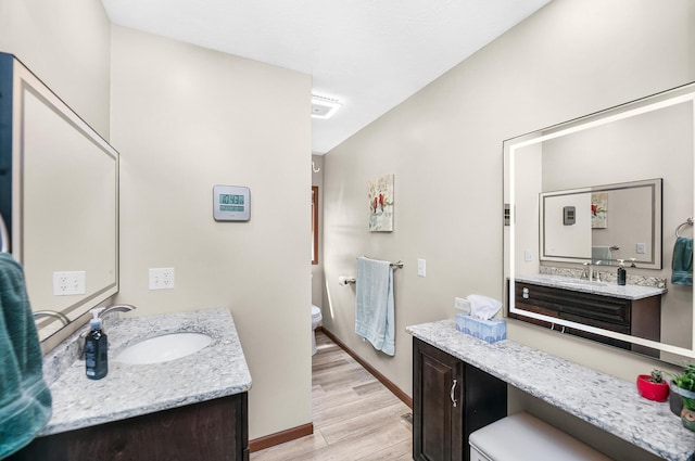 13881 Rivercrest Dr, White Pigeon, MI 49099 - bathroom with toilet, wood finished floors, baseboards, and two vanities