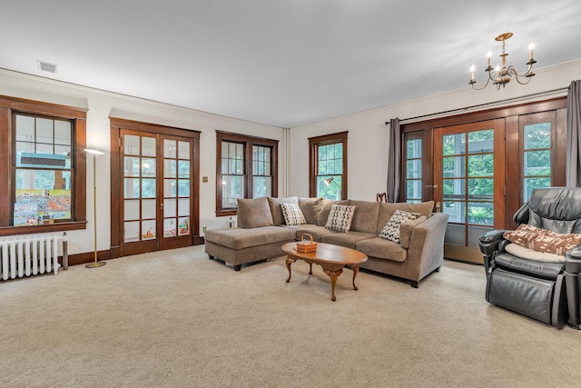 2486 Whitmore Lake Rd, Ann Arbor, MI 48105 - living area featuring radiator heating unit, french doors, a chandelier, and carpet flooring