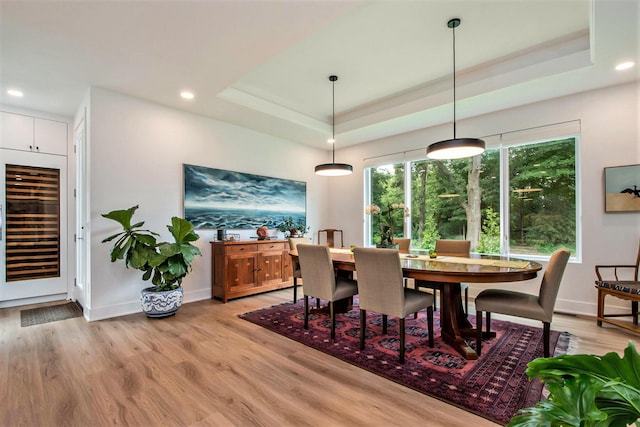 6348 Lamppost Cir SE, Grand Rapids, MI 49546 - dining area with wine cooler, a raised ceiling, light wood-style flooring, recessed lighting, and baseboards